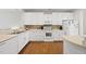 White kitchen with stainless steel appliances and hardwood floors at 8493 Central Dr, Raleigh, NC 27613