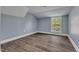 Simple bedroom with grey walls, wood-look floors and a large window at 505 S Magnolia Ave, Dunn, NC 28334