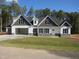 Two story home with gray and white siding, stone accents, and a large garage at 265 Coats Ridge Dr, Benson, NC 27504