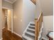 Well-lit staircase with wood railing and carpeted steps at 3108 Agecroft Rd, Raleigh, NC 27608