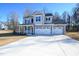 Two-story house with gray siding, stone accents, and a three-car garage at 49 Abingdon Farms Dr, Selma, NC 27576