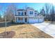 Two-story house with gray siding, stone accents, and a three-car garage at 49 Abingdon Farms Dr, Selma, NC 27576