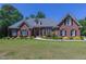 Brick home with a large lawn and mature trees at 512 W Franklin St, Zebulon, NC 27597
