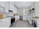 Modern kitchen with white cabinets, stainless steel appliances, and a breakfast bar at 3010 Garner Rd # 101, Raleigh, NC 27610