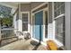 Inviting front porch with a blue door and white wicker chair at 137 Summit Oaks Ln, Holly Springs, NC 27540