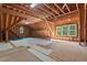 Unfinished attic space with exposed beams and windows at 488 Colvard Farms Rd, Durham, NC 27713