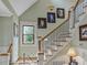 Elegant wooden staircase with wrought iron railings and framed artwork at 548 Double N Rd, Pittsboro, NC 27312
