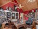 Spacious living room with red walls, wood beams, and a large bookcase at 548 Double N Rd, Pittsboro, NC 27312