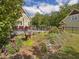 Stone patio with red chairs and fire pit, near garden at 548 Double N Rd, Pittsboro, NC 27312