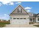 Two-car garage with stone exterior and white doors at 73 S Harper Faith Way, Benson, NC 27504