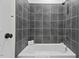 Clean bathroom with gray tile and a shower/tub combo at 488 Colvard Farms Rd, Durham, NC 27713