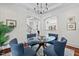 Elegant dining room features a glass table and blue chairs, offering views into the living room at 488 Colvard Farms Rd, Durham, NC 27713