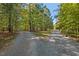 Gravel driveway leading to a house nestled amongst the trees at 488 Colvard Farms Rd, Durham, NC 27713
