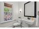 Elegant powder room featuring a pedestal sink and stained-glass window at 488 Colvard Farms Rd, Durham, NC 27713