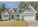 Gray two-story house with white trim, a two-car garage, and landscaping at 8126 Maude Stewart Rd, Fuquay Varina, NC 27526