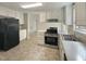 Kitchen with white cabinets, stainless steel appliances, and tile floor at 6849 Coventry Ridge Rd, Raleigh, NC 27616
