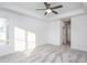 Spacious bedroom featuring carpet, ceiling fan, and access to hallway at 1724 Red Elm Lane, Homesite 76, Fuquay Varina, NC 27526