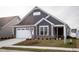 Gray house with white garage door and landscaping at 1724 Red Elm Lane, Homesite 76, Fuquay Varina, NC 27526