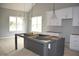 Bright kitchen with white cabinets, gray island, and large windows at 4303 Bragg Farm Ln, Franklinton, NC 27525