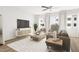 Living room with large windows, comfortable seating, and a TV at 708 Portia Way, Homesite 13, Morrisville, NC 27560