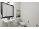Clean powder room with pedestal sink, toilet, and framed mirror at 708 Portia Way, Homesite 13, Morrisville, NC 27560