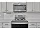 Stainless steel range and microwave in a modern kitchen with white cabinets at 86 Walker Grove Ln, Lillington, NC 27546