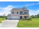 Two-story house with gray siding, stone accents, two-car garage, and basketball court at 86 Walker Grove Ln, Lillington, NC 27546