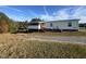 Tan single-wide mobile home with screened porch and deck at 399 Old Halifax Rd, Louisburg, NC 27549