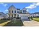 Two-story farmhouse with white siding, gray roof and a two-car garage at 616 Silver Comet Dr, Knightdale, NC 27545