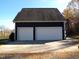 Two-car garage with white doors and dark blue exterior at 4874 Thom Rd, Mebane, NC 27302