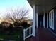 Side porch with wooden railing, brick columns, and a view of the backyard at 4874 Thom Rd, Mebane, NC 27302