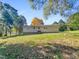 Back of house with large grassy yard and mature trees at 112 Bradsher Rd, Roxboro, NC 27574