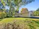 White house exterior with a large backyard and surrounding trees at 112 Bradsher Rd, Roxboro, NC 27574