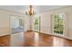 Bright dining room with hardwood floors, chandelier, and access to sunroom at 2445 Pineway Dr, Burlington, NC 27215