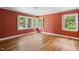 Spacious bedroom with hardwood floors, coral walls and multiple windows at 2445 Pineway Dr, Burlington, NC 27215