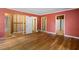 Bedroom with hardwood floors and walls painted coral; renovation in progress at 2445 Pineway Dr, Burlington, NC 27215