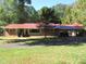 Brick ranch home with red metal roof, carport, and spacious lawn at 812 Siler City Glendon Rd, Siler City, NC 27344