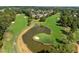 Aerial view of golf course with a pond and homes at 9432 Palm Bay Cir, Raleigh, NC 27617