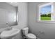 Simple powder room with white pedestal sink and a window at 23 Eagle Crest Ct # Holly English Country, Lillington, NC 27546