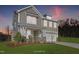 Two-story home with a neutral color scheme, two-car garage, and landscaping at dusk at 23 Eagle Crest Ct # Holly English Country, Lillington, NC 27546