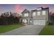 Two-story home with a neutral color scheme, two-car garage, and landscaping at dusk at 23 Eagle Crest Ct # Holly English Country, Lillington, NC 27546