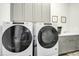 Convenient laundry room with Whirlpool washer and dryer, and upper cabinets at 117 Hardy Oaks Way, Holly Springs, NC 27540