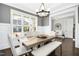Elegant dining room with a wood table, white chairs, and a chandelier at 117 Hardy Oaks Way, Holly Springs, NC 27540
