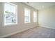Bright bedroom with neutral walls and carpet flooring, three windows at 6045 Scalybark Road, Durham, NC 27712