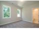 Simple bedroom with neutral walls, carpet floor and two windows at 6045 Scalybark Road, Durham, NC 27712