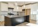 Modern kitchen with large island, white cabinets, and gray countertops at 6045 Scalybark Road, Durham, NC 27712