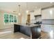 Modern kitchen with large island, white cabinets, and gray countertops at 6045 Scalybark Road, Durham, NC 27712