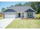 New home with blue siding, stone accents, and a two-car garage at 108 Northwood Dr, Fuquay Varina, NC 27526