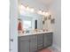 Double vanity bathroom with modern light fixtures and large mirror at 108 Northwood Dr, Fuquay Varina, NC 27526
