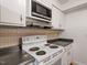 Kitchen with white appliances and dark countertops at 7040 Longstreet Dr # C, Raleigh, NC 27615